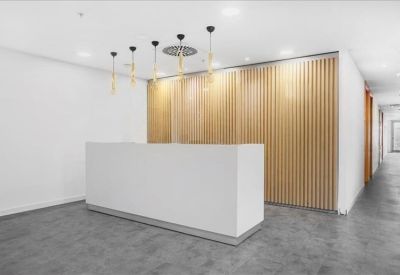 Minimalist white reception desk set against a light wood-slat feature wall.
