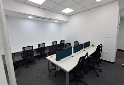 Small office nook with white desks and dark green privacy screens.