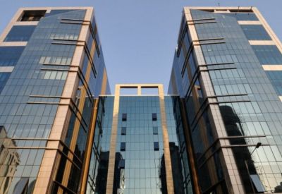 Symmetrical low-angle view of the glass and stone facade of Naman Chambers.