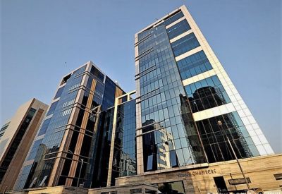 Exterior view of the multi-story glass building with gold accents against a clear blue sky.