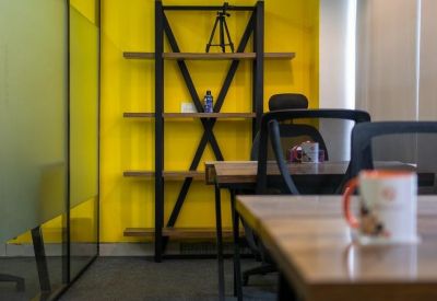 Small meeting area with a bookshelf and yellow feature wall.
