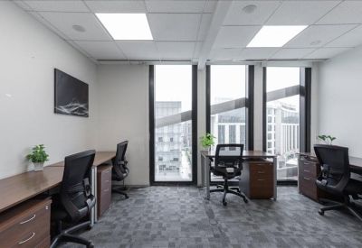 Private office suite with three desks and large windows overlooking the city.