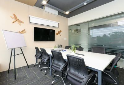 Professional meeting room with a large white conference table, black mesh chairs, and dragonfly wall art.