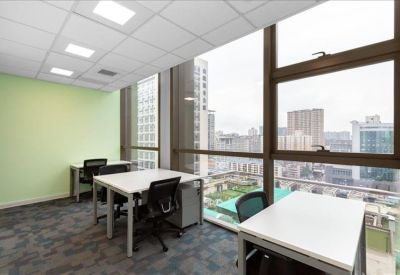 Bright office with three white desks and black chairs overlooking the city.