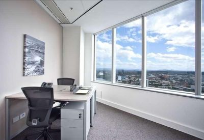 Private corner office featuring a desk and expansive windows with coastal views.
