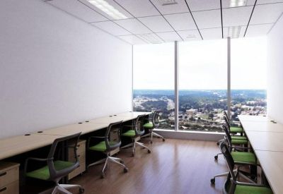 Modern office suite with long light wood desks and panoramic city views through floor-to-ceiling windows.