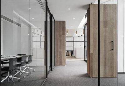 Meeting room with glass walls and black ergonomic chairs.