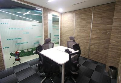 Four-person meeting room with a white table and frosted glass partitions.