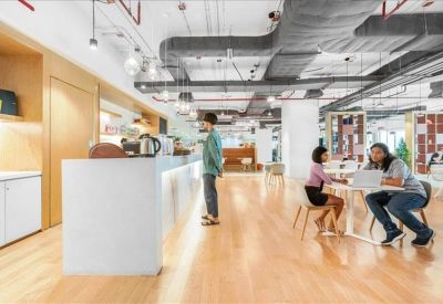 Modern breakout space featuring a long white coffee bar and collaborative seating areas.