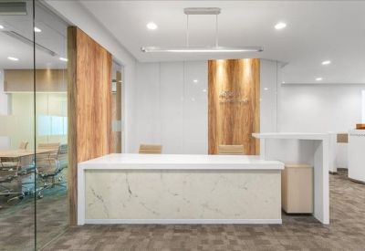 Reception area featuring a marble-fronted desk and warm wood wall accents.
