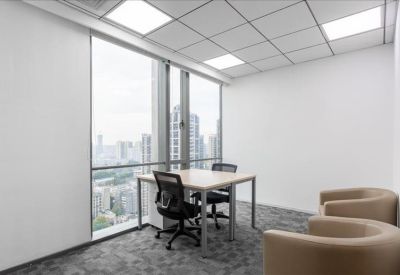 Private office with a light wood desk, ergonomic chairs, and two tan armchairs.