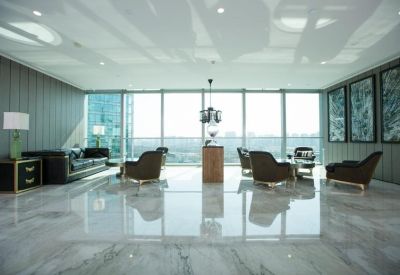 Spacious communal lounge with marble floors, plush seating, and floor-to-ceiling windows.