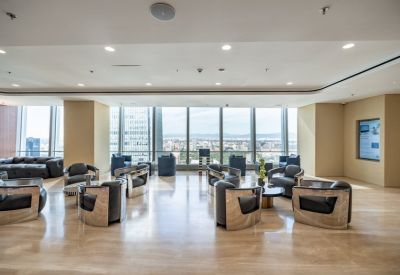 Spacious communal lounge with modern metallic armchairs and floor-to-ceiling windows.