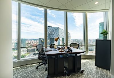 Private window office with a wooden desk and views of the CCTV Headquarters.