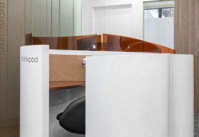 Curved white 'thinkpod' workstation with an ergonomic chair and privacy screen.