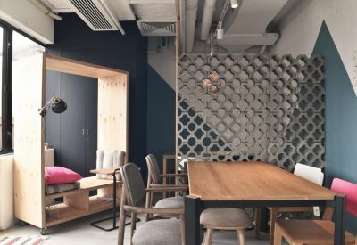 Meeting area with a large wooden table, decorative geometric screen, and blue accent wall.