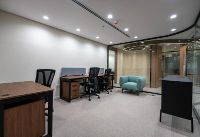 Office area with desks, chairs, and a comfortable seating area.