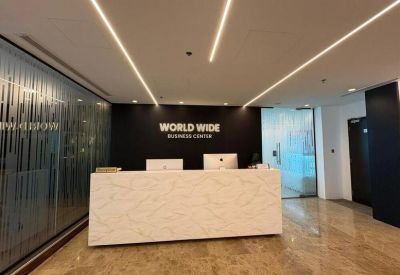 Conference room with a long light-wood table and ergonomic black chairs.