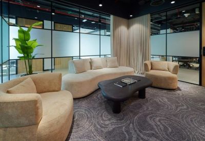 Stylish lounge area with curved beige sofas and a black marble coffee table.