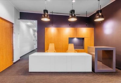 Sleek reception area with a minimalist white desk and warm wood paneling.