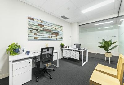 Private two-person office suite featuring white desks and a framed wall map.