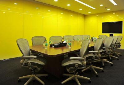Vibrant meeting room with bright yellow glass walls and a dark wood conference table.