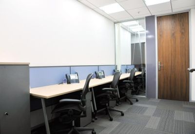 Professional three-person office suite with grey privacy partitions and wooden door.