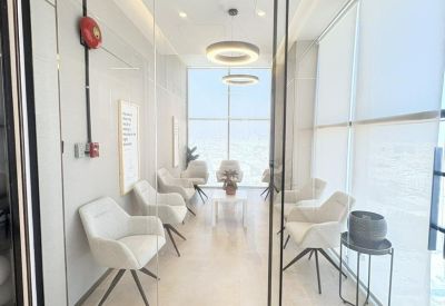 Modern meeting room with white swivel chairs and a minimalist glass partition.