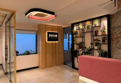 Modern reception area with wood paneling, designer ceiling light, and plant shelving.
