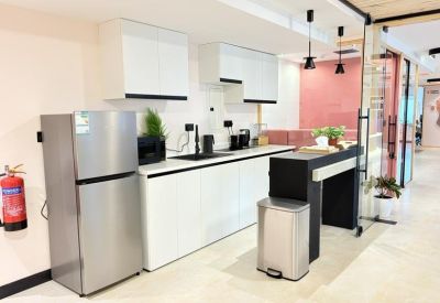 Modern kitchenette with white cabinetry and a breakfast bar.