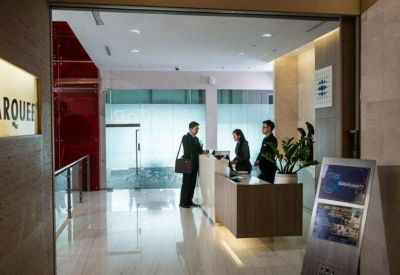 Staffed reception desk with modern white and wood finishes.