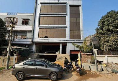 Exterior view of the modern glass and metal facade building at D-6/398, Akruti Apartments, Chitrakoot.
