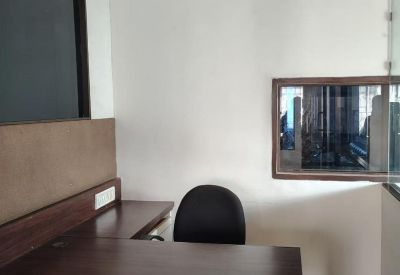 Corner office workstation featuring a dark wood desk and white cabinetry.