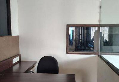 Private office suite with an L-shaped wooden desk and a glass partition wall.
