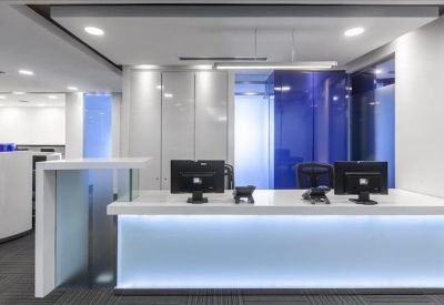 Polished reception desk with an illuminated blue base and white cabinetry.