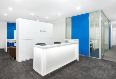 Professional reception area with a white front desk and vibrant blue walls.