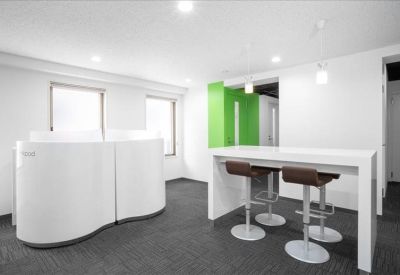 Breakout area featuring a high table with stools and a green accent wall.
