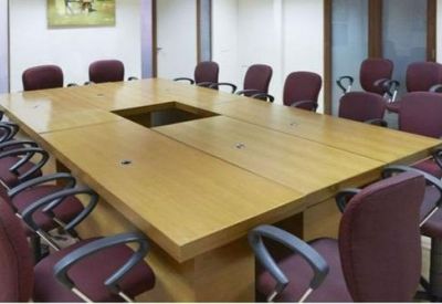 Large professional boardroom with a long wooden table and burgundy chairs.