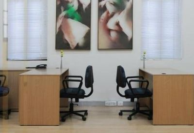 Private office space featuring two wooden desks and abstract wall art.