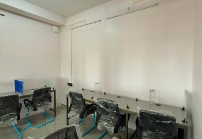 Spacious open-plan workspace with multiple desks and ergonomic chairs featuring bright blue frames.