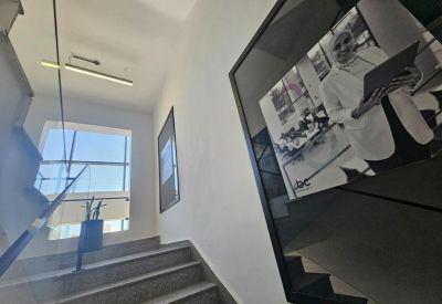 Interior staircase at VBC Naour featuring a large framed portrait on the wall.