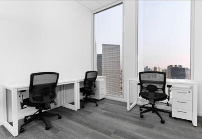 Private office suite with white desks and black mesh chairs near windows.