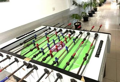 Recreational area with a foosball table and potted plants at Dilkusha Forum.