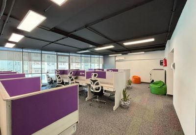 Office workstations with purple dividers and green bean bag chairs.