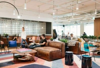 Lounge area with leather sofas, patterned rug, and industrial-style lighting.