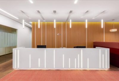 Modern white reception desk with integrated vertical lighting strips.