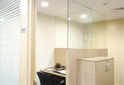 Single workstation with wooden desk and glass partitions.