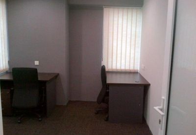 Private office featuring two wooden desks and black ergonomic chairs.