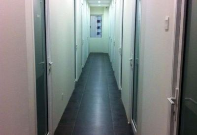 Internal corridor with tiled flooring and glass doors leading to private suites.