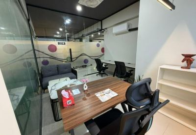 Private office space featuring a wooden desk and a comfortable guest sofa.